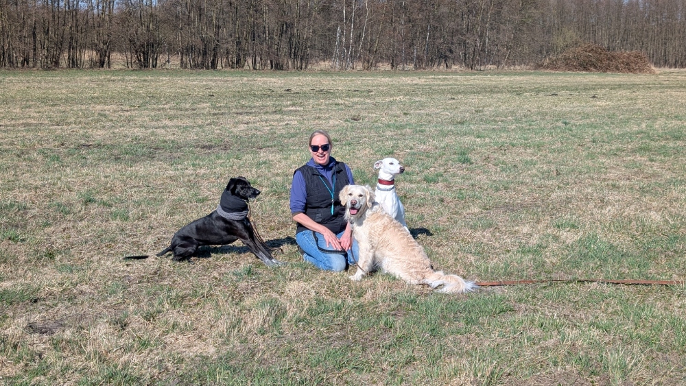 Melanie mit Hunden auf der grünen Wiese der Hundepension Berlin